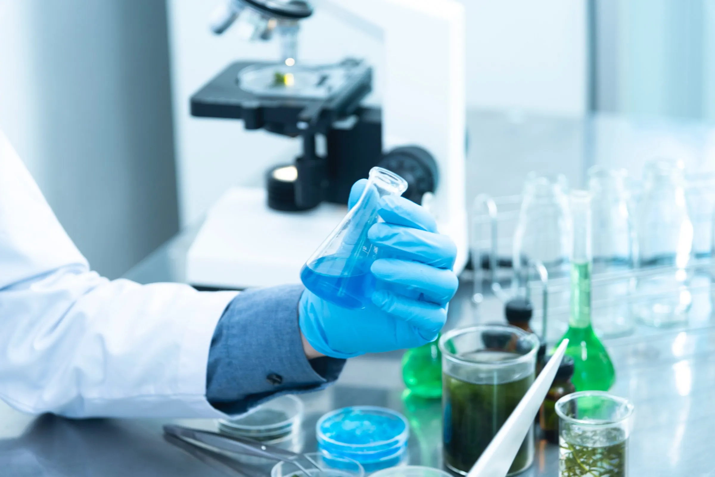 Laborant mit Erlenmeyerkolben im Analytiklabor