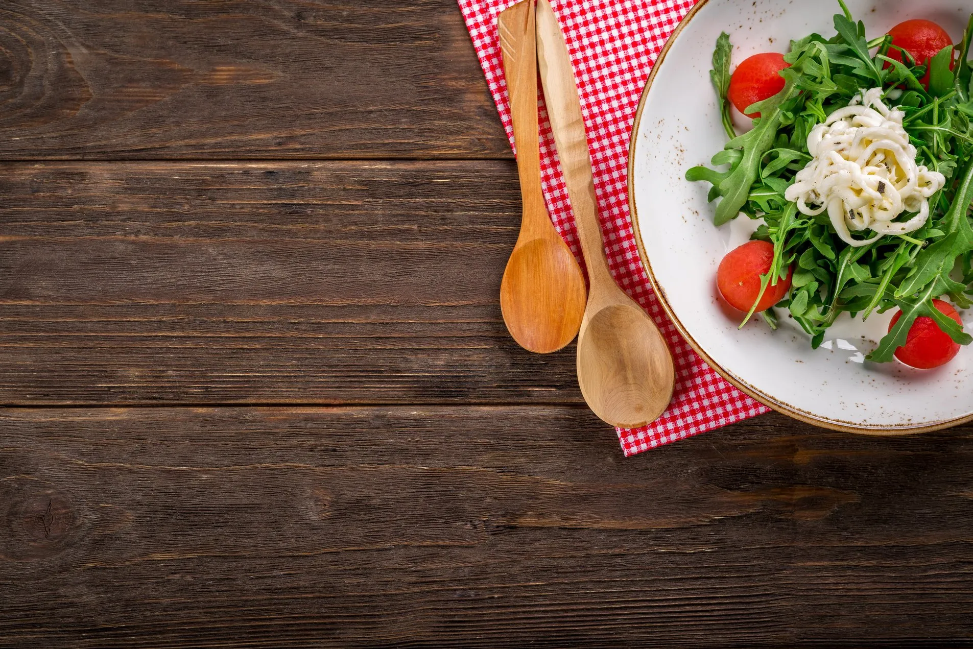 Schale mit frischem Salat auf einem Holztisch